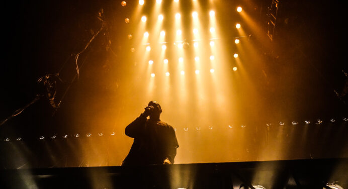 Un fanático trata de montarse en la tarima flotante de Kanye West