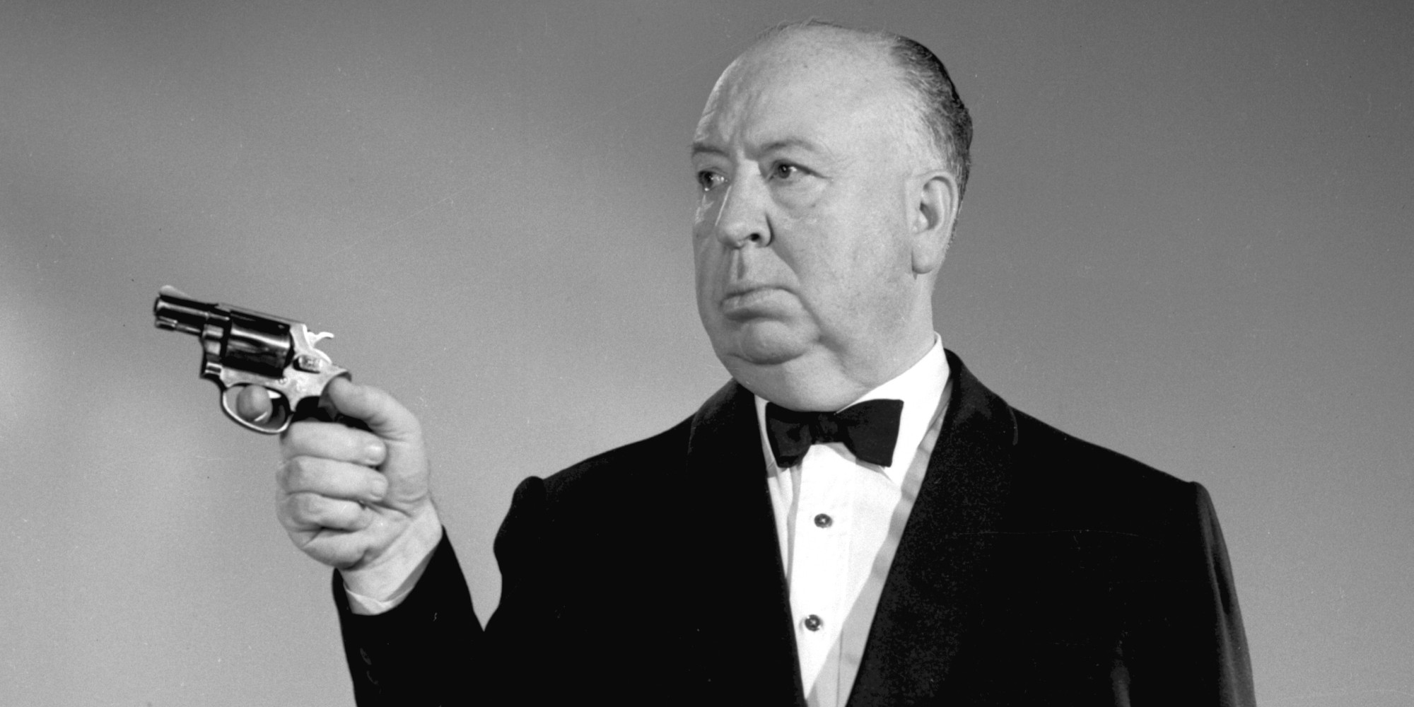 Promotional portrait of British-born American film and television director Alfred Hitchcock (1899 - 1980), dressed in a tuxedo, as he aims a revolver for his anthology program 'The Alfred Hitchcock Hour,' December 12, 1962. (Photo by CBS Photo Archive/Getty Images)